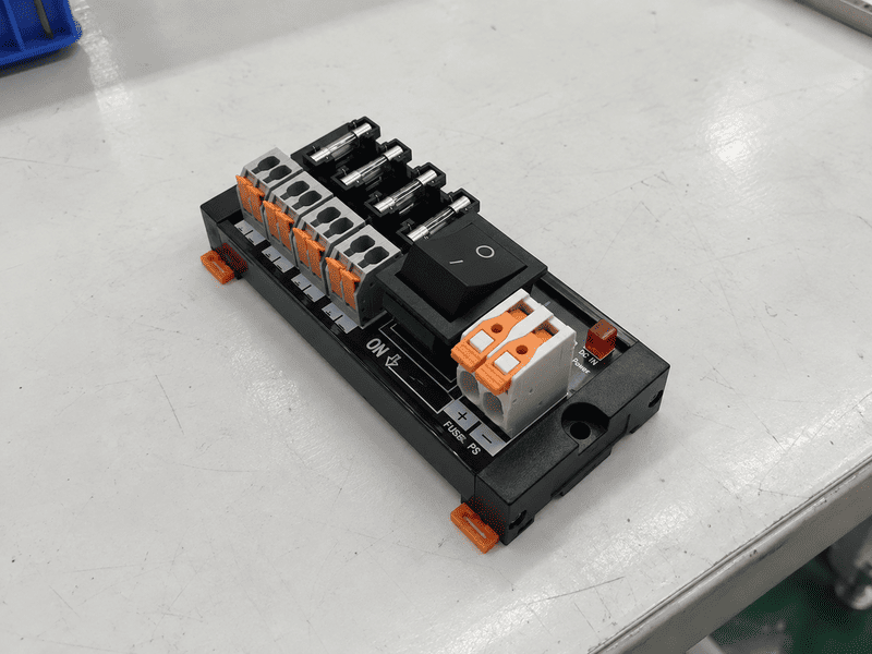 Two-channel DC power distribution module with spring terminals, switches, LEDs, and a replaceable fuse